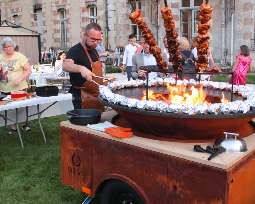 Chef cuisinier préparant des brochettes au feu de bois